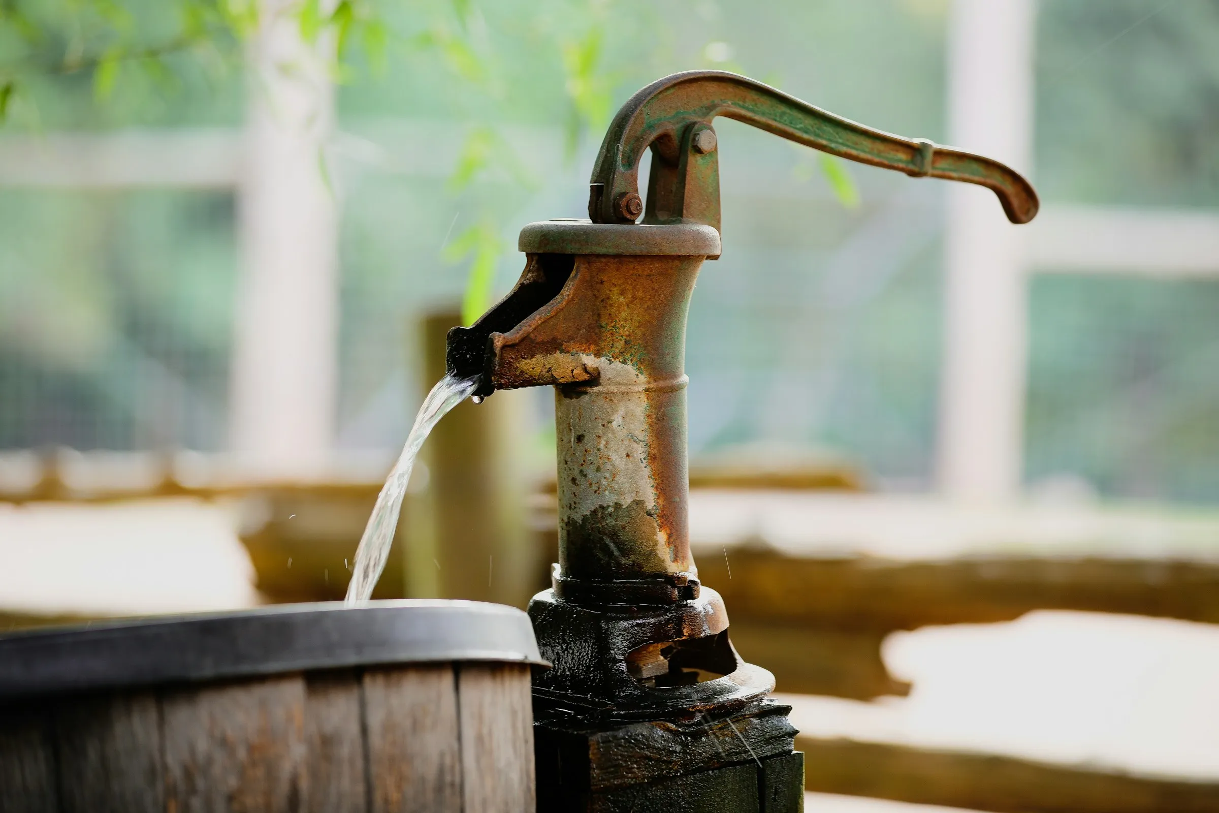 Water pouring from a brown wooden bucket.